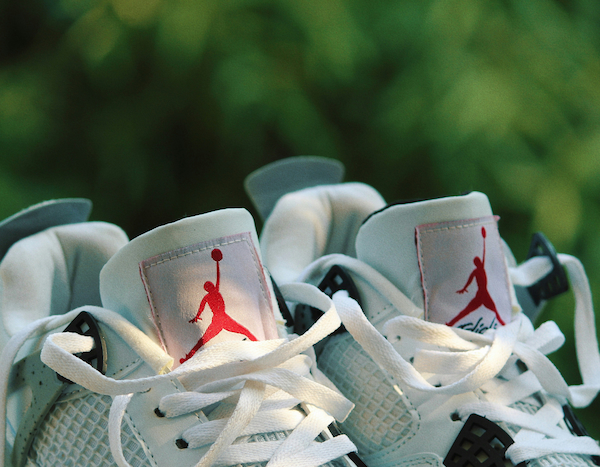 Close-up of white sneakers with red logo detailing